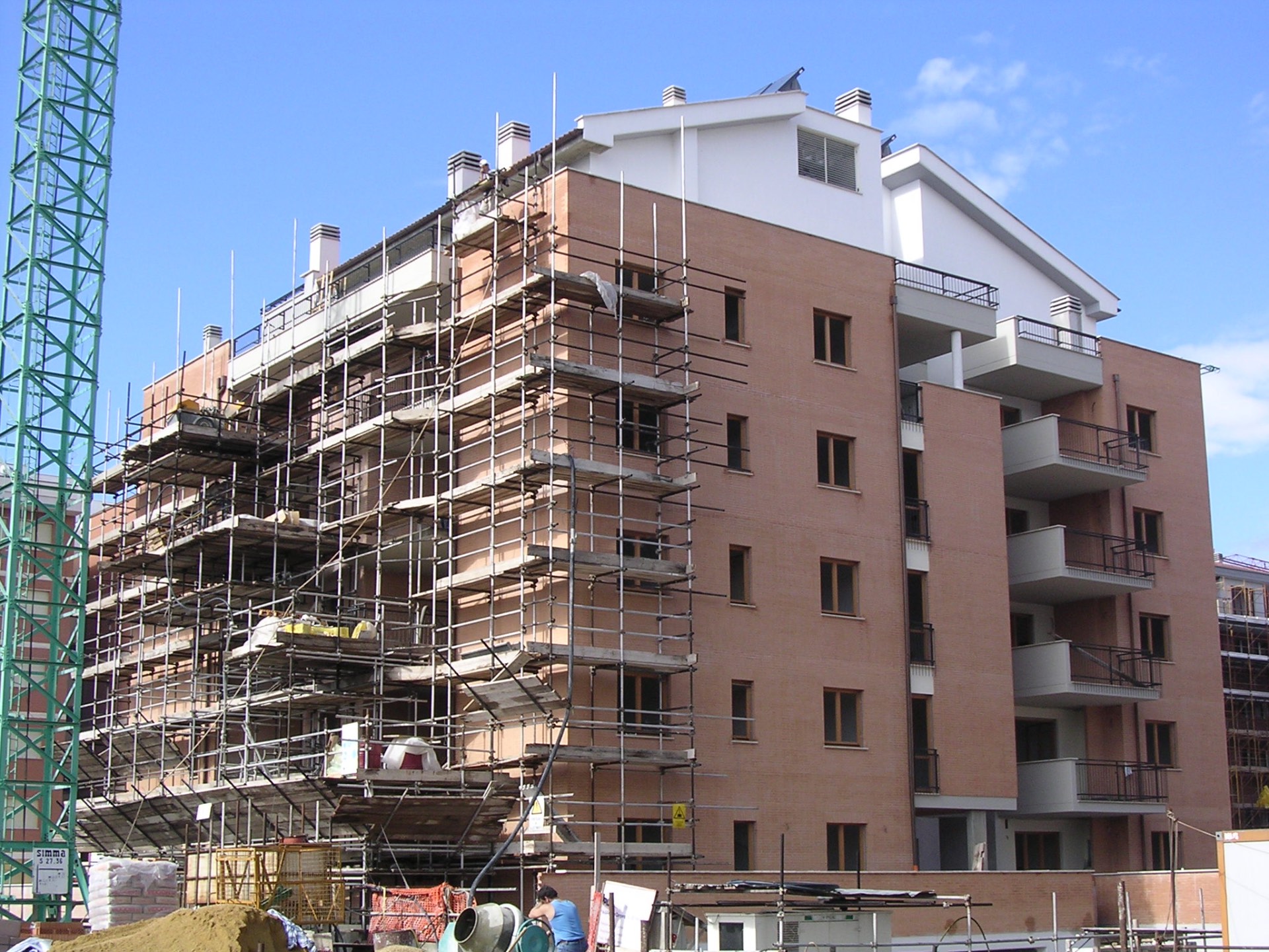 Edificio residenziale in costruzione con ponteggi e gru di cantiere